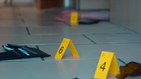 Sliding-Long-Shot-of-Evidence-Tags-On-Floor-at-Crime-Scene