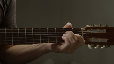 Plano-Medio-De-La-Mano-De-Los-Guitarristas-En-El-Traste-De-La-Guitarra-Acústica