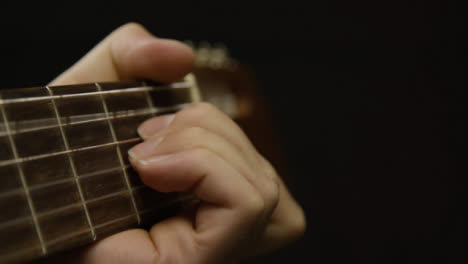 Tracking-Shot-Approaching-Musicians-Hand-On-Acoustic-Guitar-Fret-Board