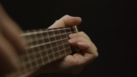 Tracking-Shot-Approaching-Musicians-Hand-On-an-Acoustic-Guitar-Fret-Board