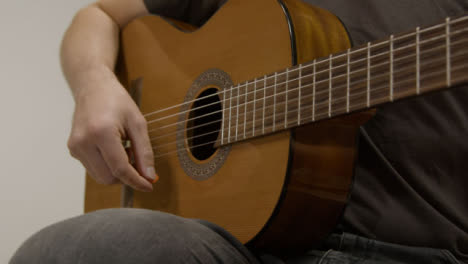 Tracking-Shot-Past-Acoustic-Guitar-Head-as-Musician-Plays