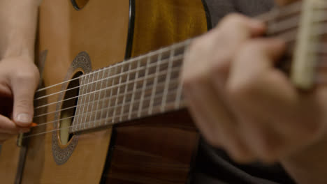 Primer-Plano-De-La-Mano-De-Los-Músicos-En-El-Traste-De-La-Guitarra-Acústica