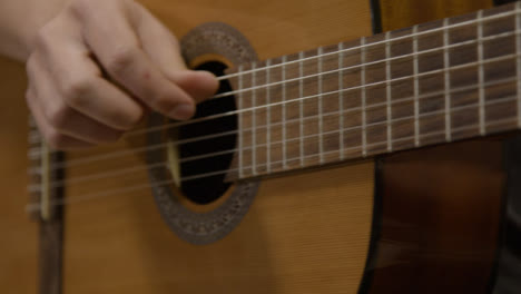 Tracking-Shot-Past-Musicians-Hand-Playing-Acoustic-Guitar