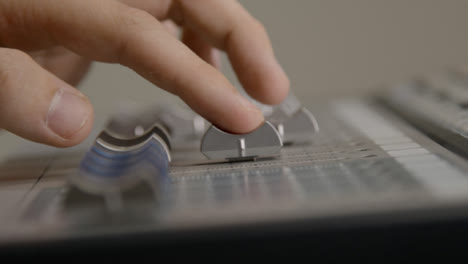 Close-Up-Shot-of-Sound-Mixers-Hand-Adjusting-Faders-