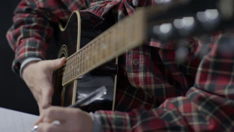 Plano-Medio-De-Músico-Tocando-La-Guitarra-Y-Escribiendo-En-El-Bloc-De-Notas