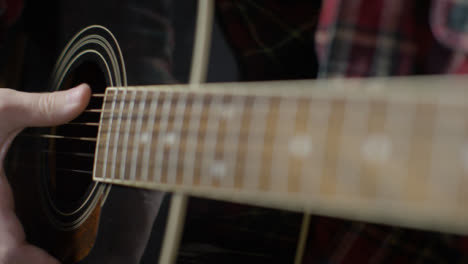 Tire-De-La-Toma-De-Enfoque-Desde-El-Traste-Al-Cuerpo-De-La-Guitarra-Acústica-Mientras-El-Músico-Toca