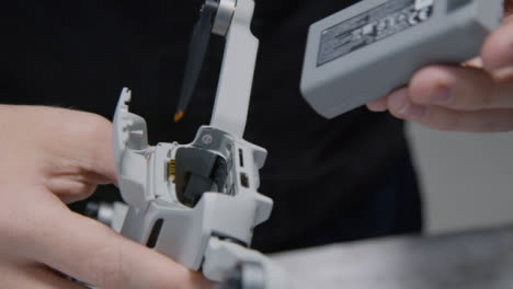 Close-Up-Shot-of-Person-Inserting-Battery-into-DJI-Mini-2