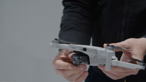 Close-Up-Shot-of-Person-Folding-Out-Arms-On-a-DJI-Mini-2