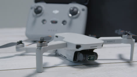 Kamerafahrt-Im-Orbit-Von-Dji-Mini-2-Drohne-und-Controller-Auf-Der-Tischoberfläche