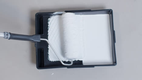 High-Angle-Shot-of-Roller-In-Paint-Tray-with-White-Paint