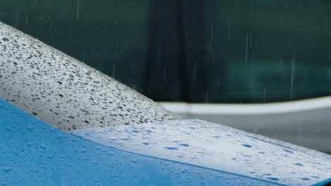 Lange-Aufnahme-Von-Starkem-Regen,-Der-Auf-Blaues-Autofenster-und-Karosserie-Fällt
