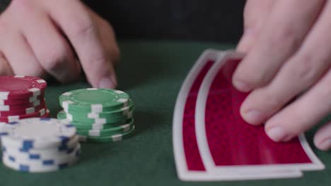 Tracking-Close-Up-Shot-from-Cards-to-Poker-Chips-Being-Thrown-In-