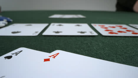 Sliding-Extreme-Close-Up-Shot-of-Poker-Player-Turning-Over-Pocket-Aces