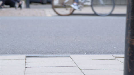 Medium-Shot-of-Pavement-as-Bus-and-People-Pass-In-Background