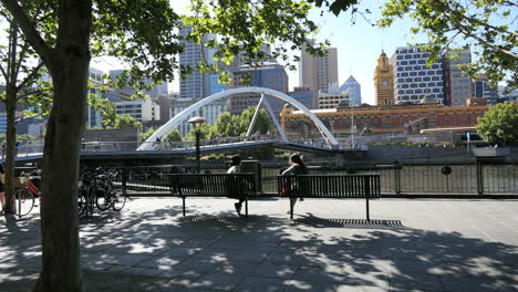 Melbourne-Australia-foot-bridge-Yarra-River-beyond-girls-on-bench