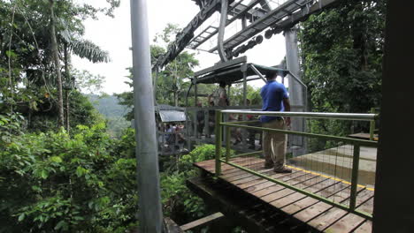 Costa-Rica-man-pulls-cable-car-toward-platform-rainforest