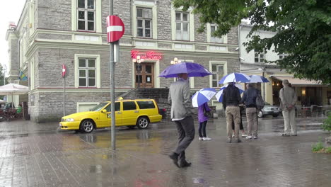 Tallin-Estonia-En-Un-Día-Lluvioso-Con-Gente-Y-Un-Taxi-Amarillo