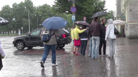 Tallinn-Estland-Menschen-Mit-Regenschirmen-überqueren-Die-Straße