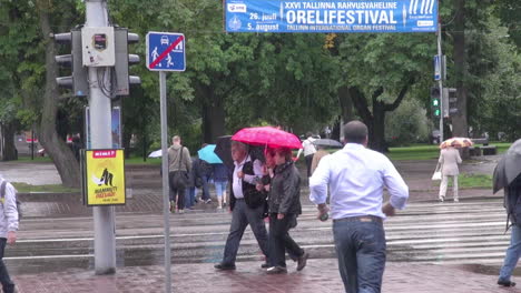 Tallinn-Estland-Leute-Mit-Regenschirmen,-Die-Im-Regen-Laufen-und-Laufen