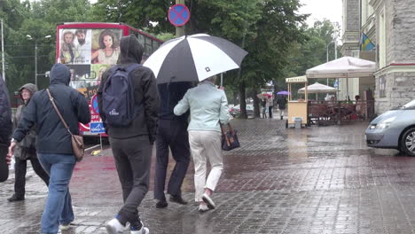 Tallinn-Estland-Leute-Mit-Regenschirmen,-Die-Im-Regen-Laufen