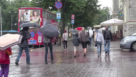 Tallinn-Estland-Roter-Bus-und-Leute,-Die-Mit-Regenschirmen-Gehen