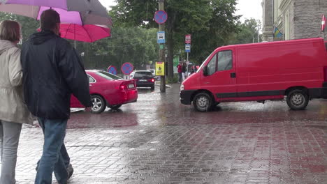 Tallinn-Estland-Roter-Lieferwagen-und-Auto-und-Leute-Mit-Regenschirmen