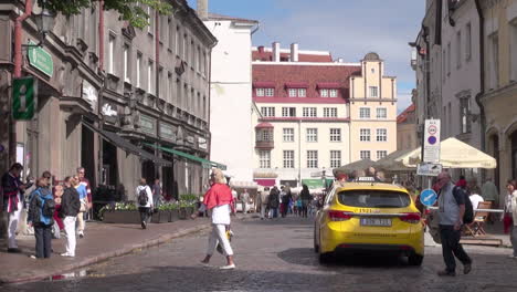 Tallinn-Estonia-street-scene-with-yellow-taxi-and-tourists