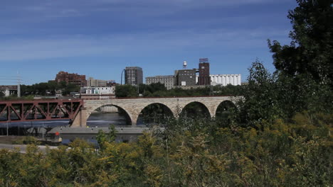Minneapolis-Minnesota-Steinbogenbrücke-und-Skyline-Dahinter