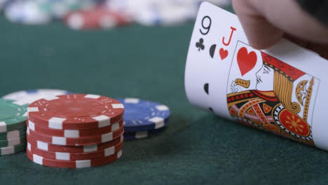 Extreme-Close-Up-Shot-of-Poker-Player-Checking-Cards-Before-Betting