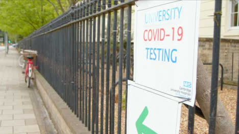 Kamerafahrt-Vorbei-Am-Covid-19-Testzentrum-Schild-Auf-Metallgeländer