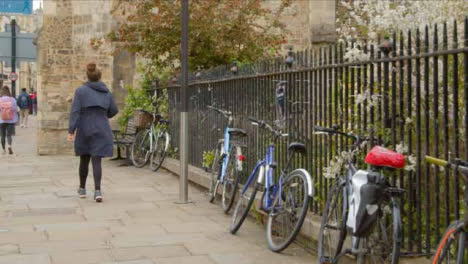 Tracking-Shot-Following-Pedestrian-Walking-Next-to-Bicycles-Tied-to-Railing