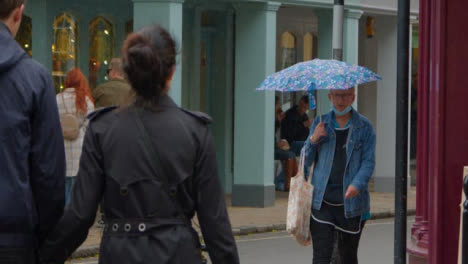 Long-Shot-of-Shoppers-Walking-In-Rain