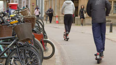 Tiro-De-Seguimiento-Al-Otro-Lado-De-La-Calle-Mientras-Los-Scooters-Eléctricos-Pasan