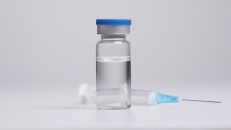 Tracking-Shot-Approaching-Vial-of-Translucent-Liquid-and-Syringe