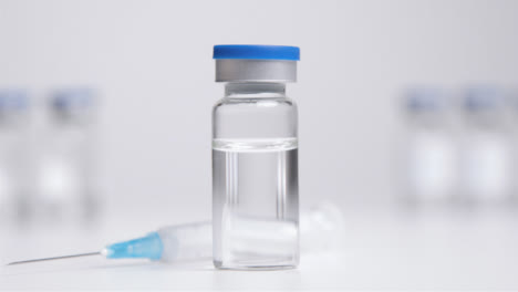 Tracking-Shot-Approaching-Vial-of-Translucent-Liquid-and-a-Syringe