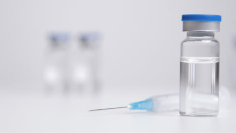 Sliding-Shot-of-Vial-of-Translucent-Liquid-and-Syringe