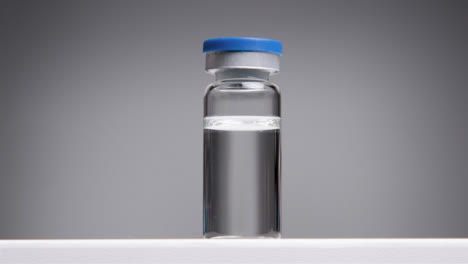 Low-Angle-Tracking-Shot-Approaching-Vial-of-Translucent-Liquid-