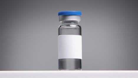 Low-Angle-Tracking-Shot-Approaching-Vial-with-Clean-White-Label