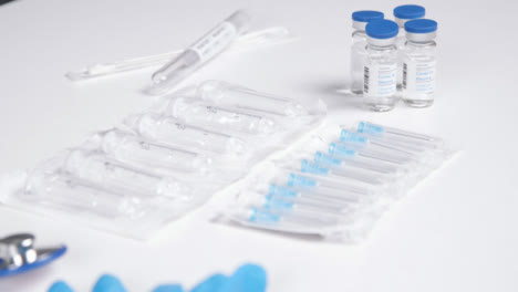 Fokusaufnahme-Von-Blauen-Latexhandschuhen-Auf-Covid-19-Impfstofffläschchen-Ziehen