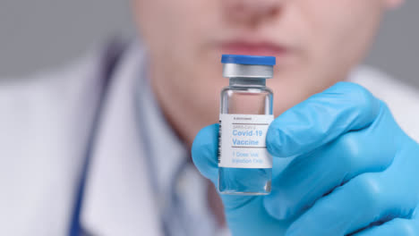 Close-Up-Shot-of-Medical-Professionals-Hand-Holding-Up-Covid-19-Vaccine-Vial-