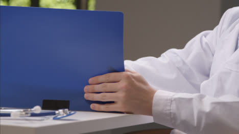 Tracking-Shot-Orbiting-Medical-Professional-Working-at-His-Desk