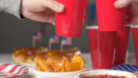 Sliding-Shot-Over-Party-Food-as-People-Bring-Cups-Together-In-a-Cheers