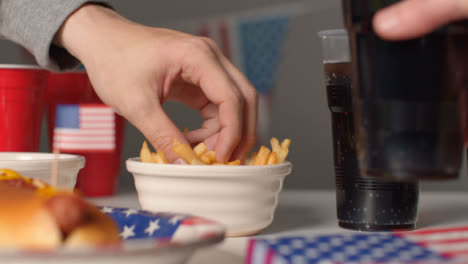 Sliding-Shot-Approaching-Bowl-of-Fries-as-Hand-Takes-Some