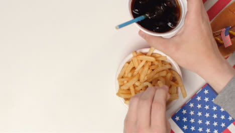 Top-Down-Shot-of-Hands-Taking-Fries-and-Soda-from-Table-with-Copy-Space