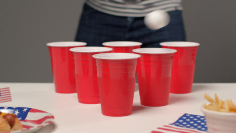 Sliding-Shot-Approaching-Plastic-Cups-as-a-Person-In-the-Background-Plays-Beer-Pong
