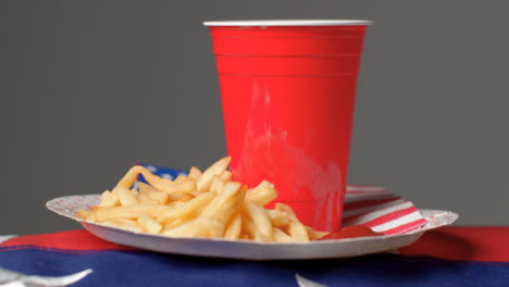 Close-Up-Shot-of-Rotating-Plate-of-Fries-with-Red-Plastic-Beer-Cup