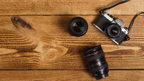 Top-Down-Shot-of-Person-Picking-Up-SLR-Camera-from-Table