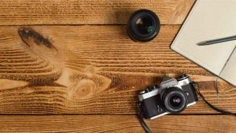 Top-Down-Shot-of-Person-Placing-SLR-Camera-On-Table-with-Left-Copy-Space