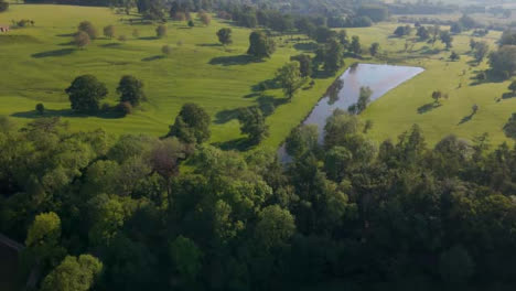 Drone-Shot-Approaching-Small-Body-of-Water-In-Cotswolds