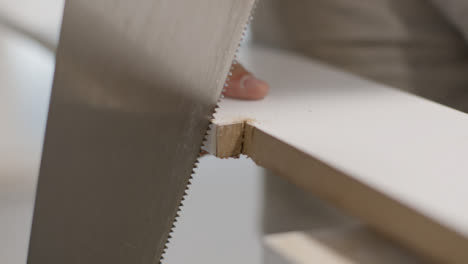 Close-Up-Shot-of-Hand-Saw-Being-Used-to-Cut-Skirting-Board